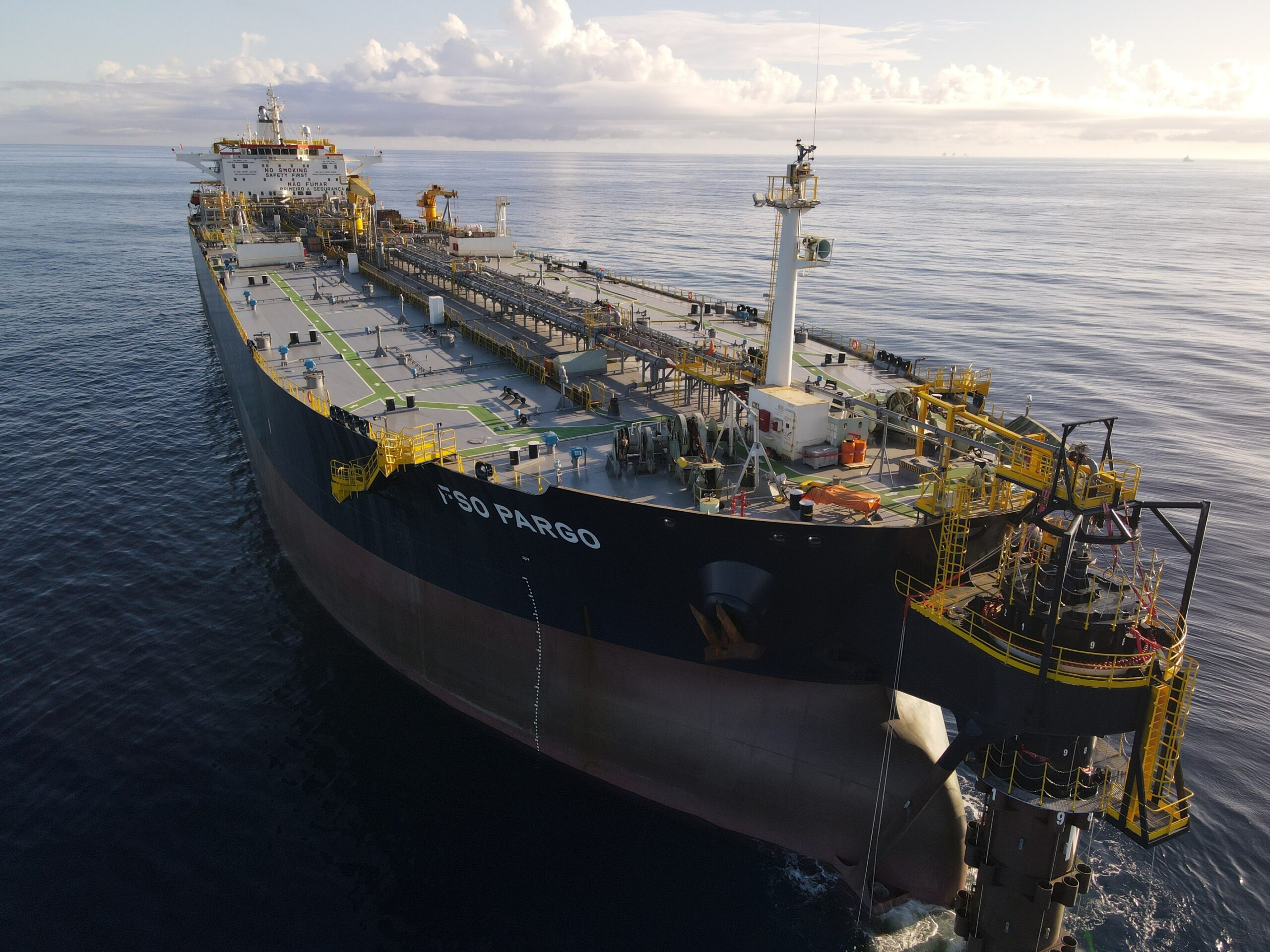 Floating long cargo boat navigating in the middle of the sea